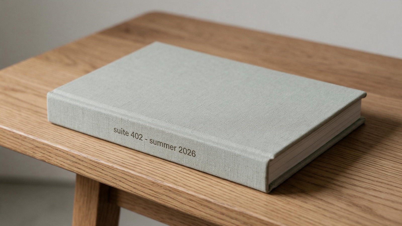 A linen-bound book, its spine stamped with a porch name and season, resting on an oak table.